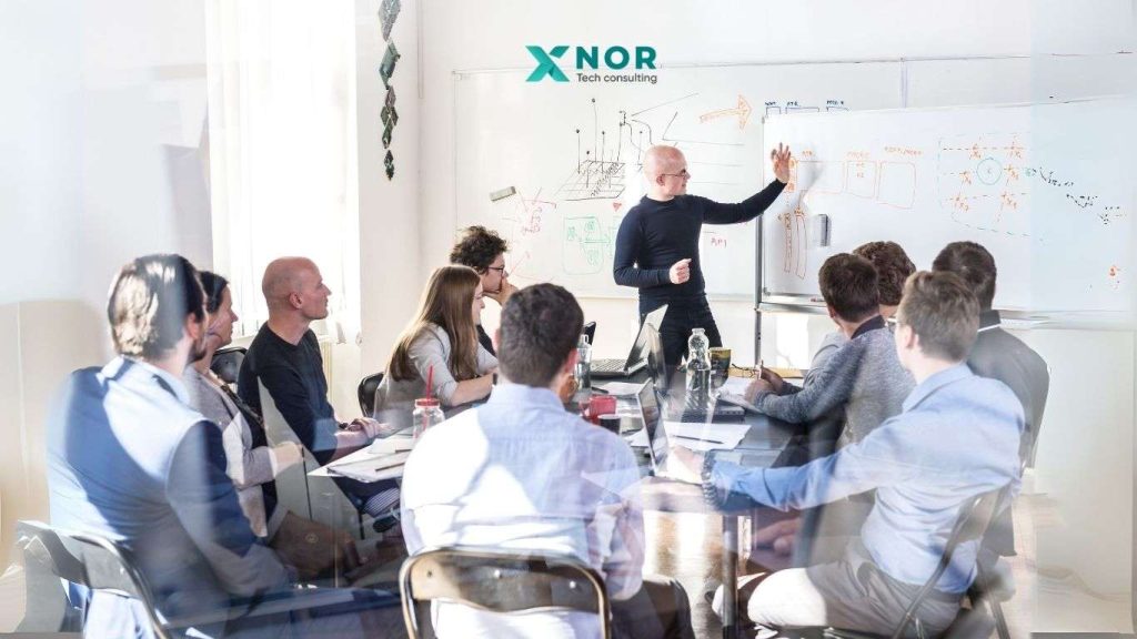 XNOR Group tech consulting team in a professional meeting with executives discussing software development solutions.